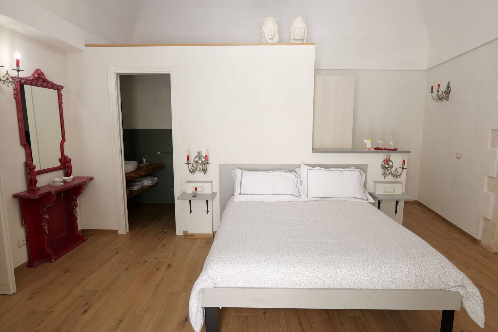 Camera Amore Vero: letto matrimoniale e consolle rossa con lo specchio