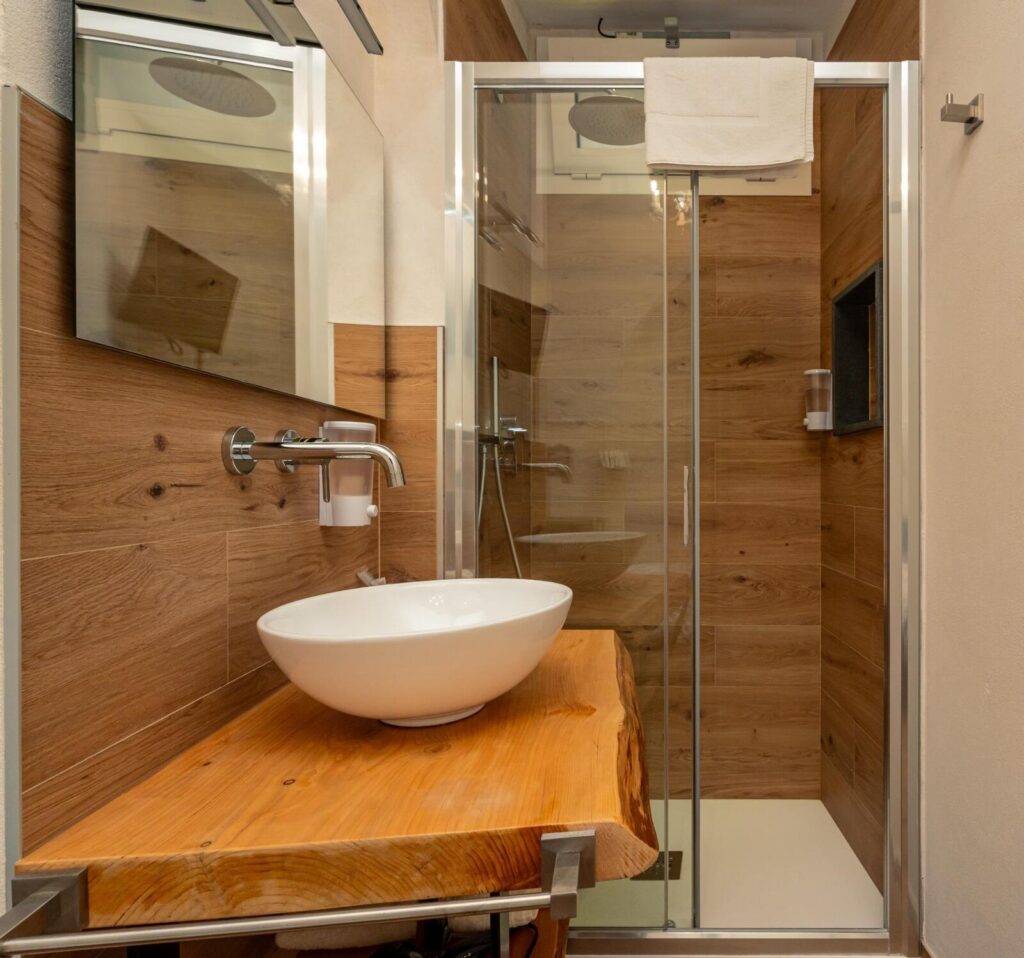 Camera Castello: doccia a vista con lavabo su legno