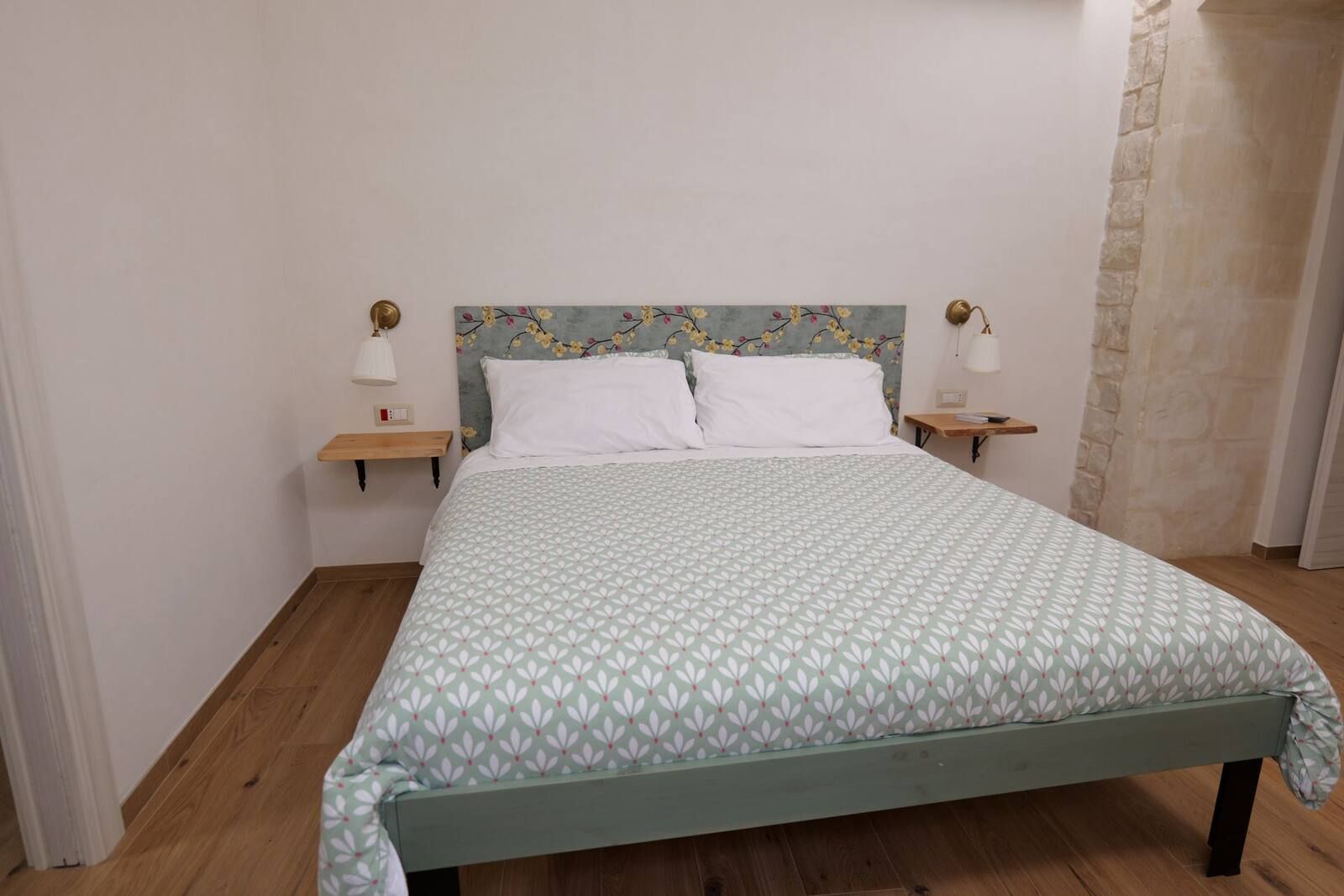 Camera Idria: letto matrimoniale con la testiera verde decorata