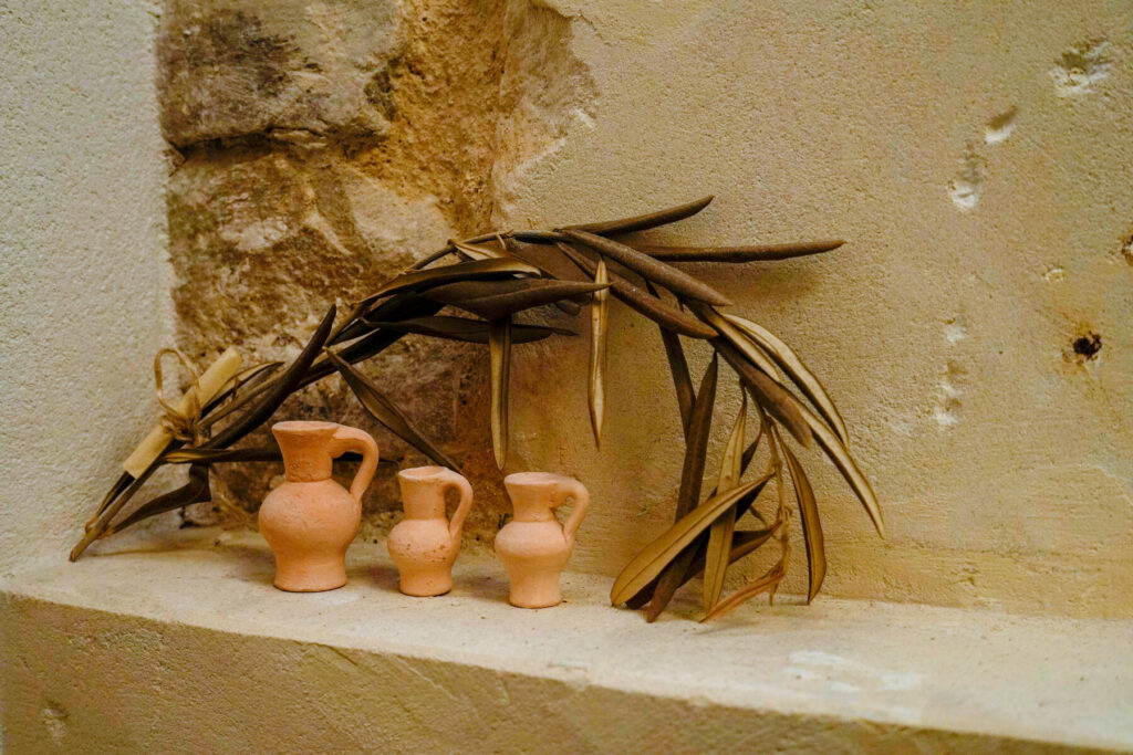 Brocche di terracotta e foglie di palma su una mensola di pietra