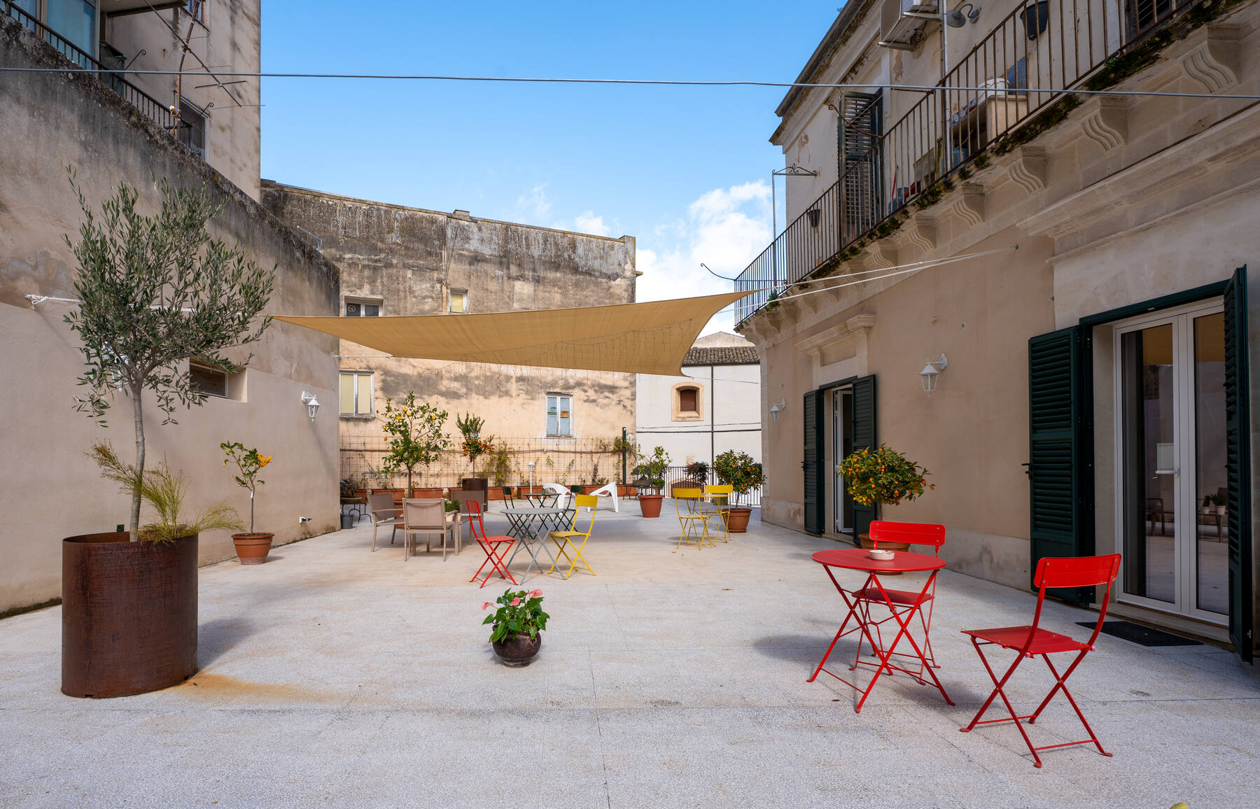 La terrazza con le sedie rosse e la vela ombreggiante