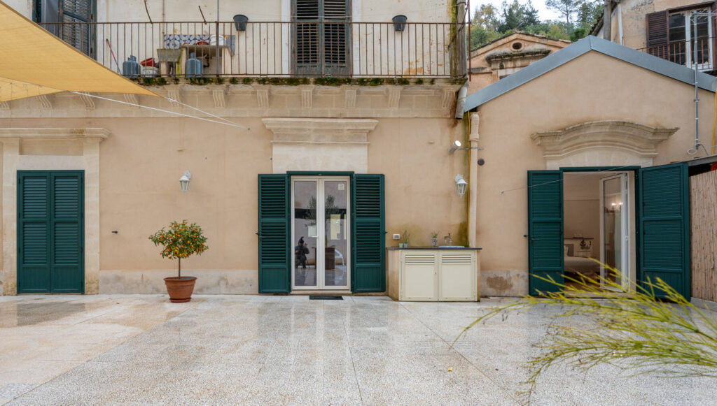La terrazza con le persiane verdi della casa